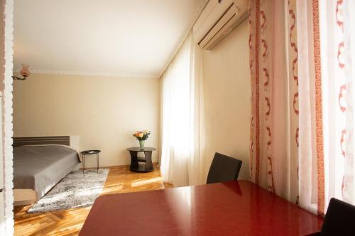 尼古拉耶夫Уютная квартира в центре的卧室配有桌子和一张位于客房内的床