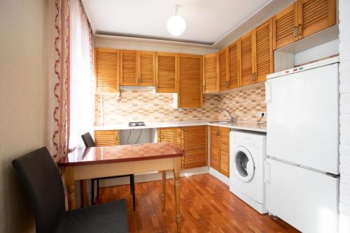 尼古拉耶夫Уютная квартира в центре的厨房配有桌子和洗衣机。