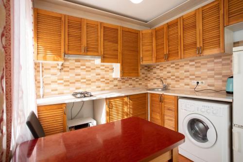 尼古拉耶夫Уютная квартира в центре的厨房配有木制橱柜和洗衣机。