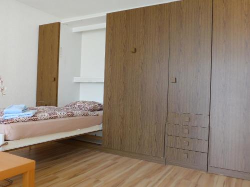 采尔马特Apartment Imperial-5 by Interhome的一间卧室配有一张床和一个木制橱柜