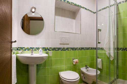 圣安吉洛回到索伦托的绿色和白色的浴室设有水槽和卫生间