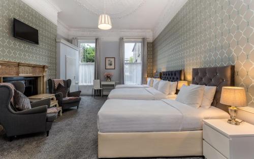都柏林Clifden House by Nina的酒店客房设有两张床和壁炉