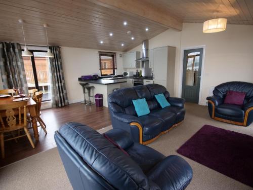 BallingryChalet Loch Leven Lodge by Interhome的带沙发和椅子的客厅以及厨房。
