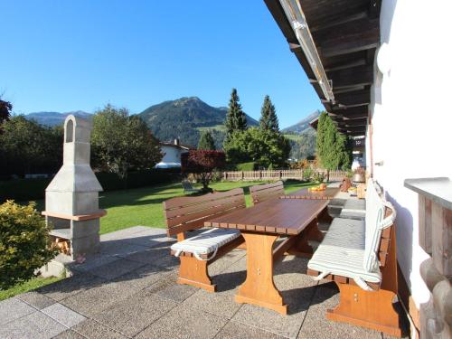 乌登斯Holiday Home Sonnblick by Interhome的山地庭院的野餐桌和长椅