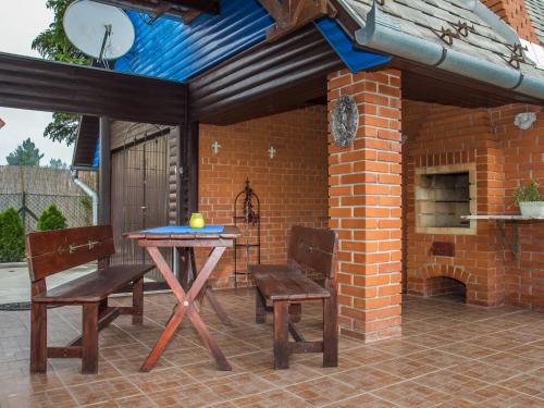 鲍洛通凯赖斯图尔Holiday Home Blue by Interhome的庭院设有桌子、两把椅子和砖砌壁炉。