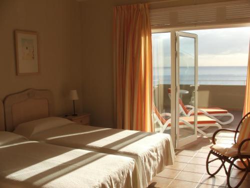 波多·纳奥斯穆拉雅公寓的一间带两张床的卧室和一个海景阳台