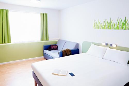 沃灵顿Warrington Motel, J20 M6 Lymm Services的一间卧室配有一张床和一张沙发