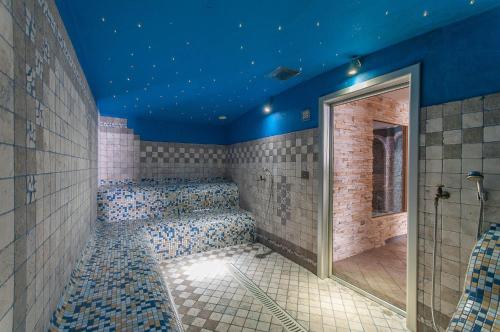 迪马罗Alpholiday Dolomiti Wellness & Family Hotel的以及1间带蓝色墙壁和蓝色天花板的浴室。
