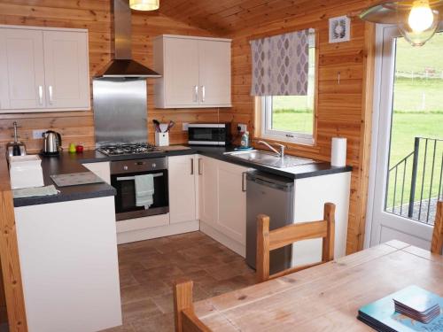 金罗斯Chalet Osprey Lodge by Interhome的厨房配有白色橱柜和炉灶。