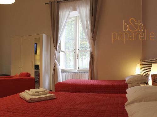 科森扎帕帕尔蕾住宿加早餐旅馆的一间卧室设有两张带红色床单的床和窗户。