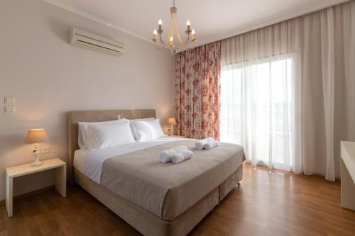 伊利索斯Chrissiida Villa的一间卧室配有一张床,上面有两条毛巾
