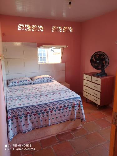 卡诺格布拉达Suítes D'Belinha的一间卧室配有床、窗户和梳妆台