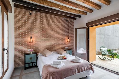 GuadamurCasa Rural de Ancos, Guadamur, Toledo的一间卧室设有一张大床和砖墙