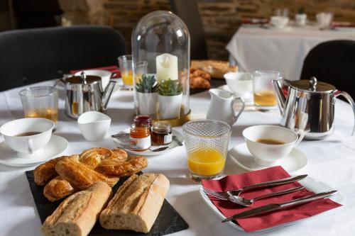 康卡勒La Metairie-du-Vauhariot - Chambre Ou Lodge - Piscine Chauffée - Vue Mer et Mont Saint Michel - GR34的一张桌子,上面有面包、咖啡和饮料