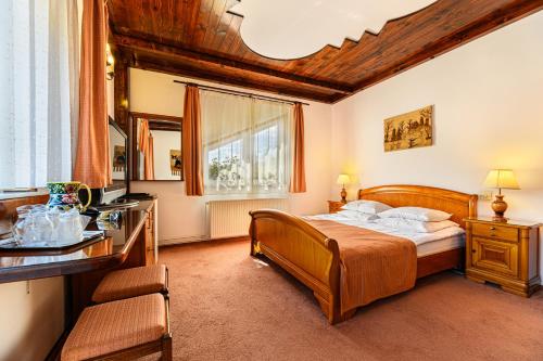 普雷代亚尔Regina的一间卧室配有一张床、一张书桌和一个窗户。