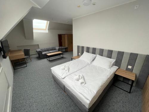 克罗托申Hotel Wodnik的一间卧室配有带白色床单和枕头的床。