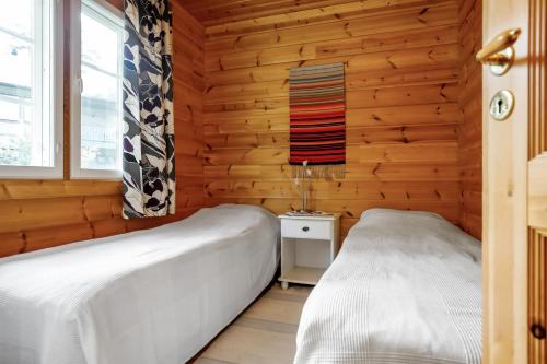 SysmäCottage Kivitatti的木墙客房的两张床