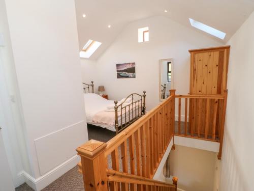 WolsinghamDrover's Cottage的楼梯通往卧室,卧室配有床