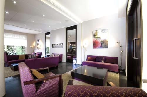 索恩河畔自由城普莱桑斯西佳酒店的客厅配有紫色的沙发和椅子
