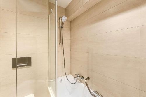 布鲁塞尔斯蒂芬妮NH酒店的浴室里设有玻璃门淋浴