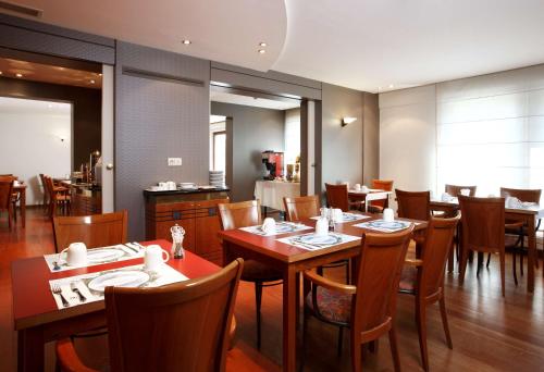 梅赫伦NH梅赫伦酒店的用餐室配有木桌和椅子