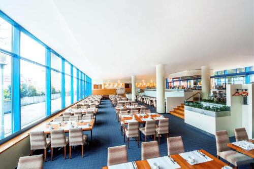 布拉格布拉格市NH酒店的用餐室设有桌椅和窗户。