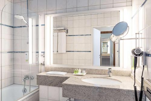因戈尔施塔特NH因戈尔施塔特酒店的一间带水槽、镜子和淋浴的浴室