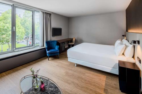 阿姆斯特丹阿姆斯特丹卡兰萨NH酒店的配有一张床和一张书桌的酒店客房