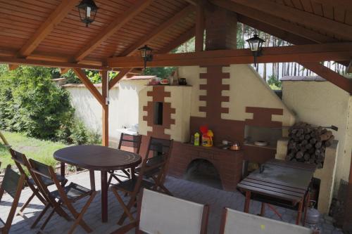 比得哥什威拉马克西米利安住宿加早餐旅馆的庭院设有砖砌壁炉、桌子和椅子