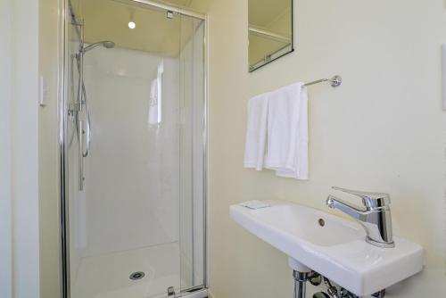 GlendhuGlendhu Station Cottage - Glendhu Bay Holiday Home的白色的浴室设有水槽和淋浴。