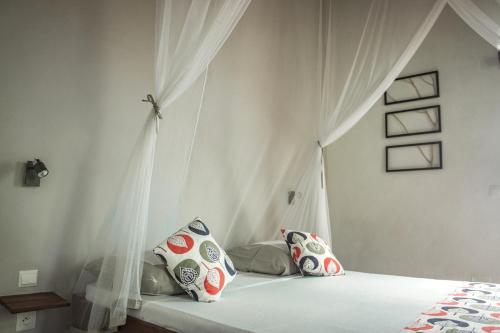MadirokelyChez Senga的一间卧室配有一张带天蓬和枕头的床
