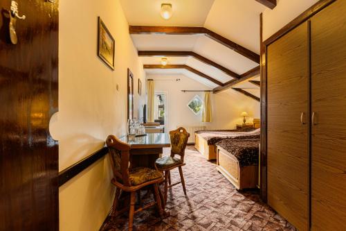 普雷代亚尔布拉杜尔膳食公寓酒店的一间卧室配有一张床、一张桌子和一把椅子