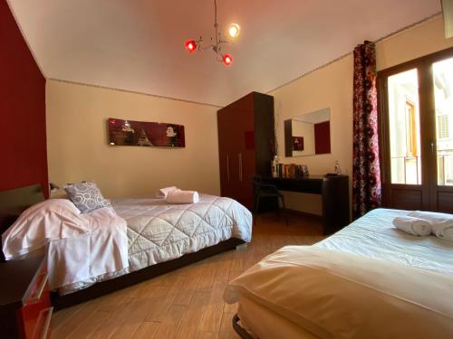 切法卢切法卢多奇酒店的一间卧室设有两张床、一张桌子和一个窗口。