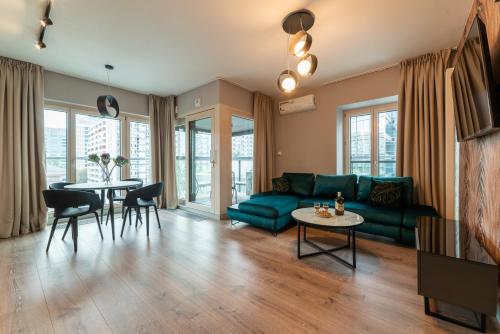 华沙Mennica Residence的客厅配有绿色沙发和桌子