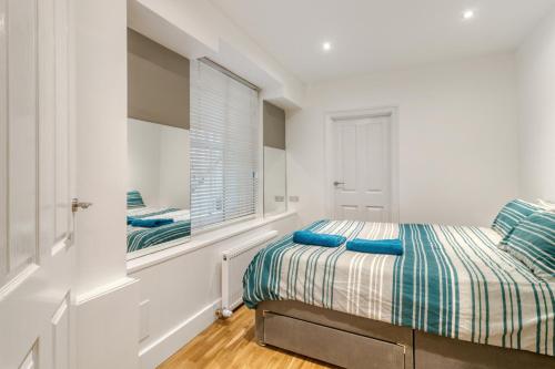 伦敦Holland Park Apartment的白色的卧室设有床和窗户