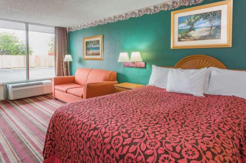 迈尔斯堡迈尔斯堡南/机场戴斯酒店的酒店客房配有红色的床和椅子