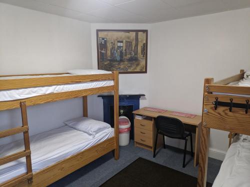 哈洛HARLOW INTERNATIONAL HOSTEL的宿舍间设有两张双层床和一张书桌。