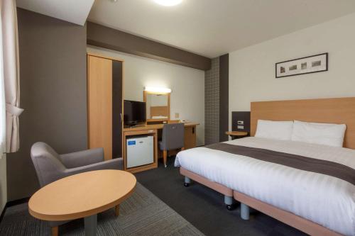 成田成田机场康福特茵酒店的配有一张床和一张书桌的酒店客房