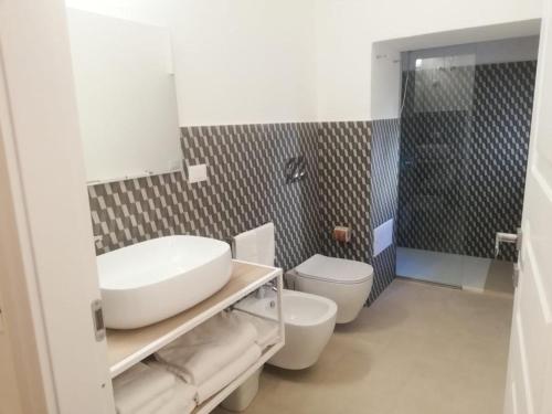 锡拉库扎加加略酒店的一间带水槽、卫生间和淋浴的浴室