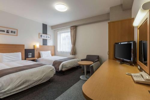 仙台仙台东部舒适酒店的酒店客房设有两张床和一台平面电视。