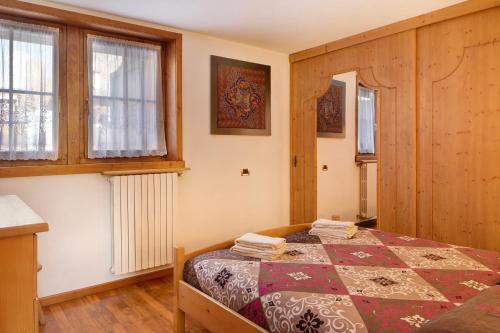 利维尼奥Chalet Maffins 1的一间卧室设有一张床和两个窗户。
