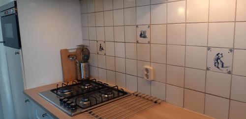 霍勒姆比耶迪福尔特伦公寓的厨房配有炉灶和瓷砖墙。