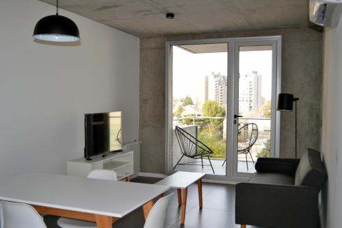 内乌肯Loi Flats Edificio Tucuman的客厅配有桌子、电视和窗户。