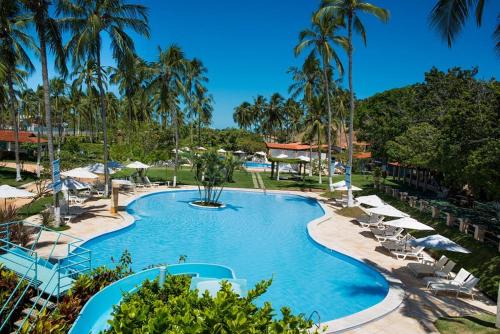 帕里普埃拉Casa Eco Fiore 58的度假村的游泳池配有椅子和遮阳伞