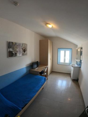 Staranzano阿尔贝格拉卡拉维拉酒店的一间卧室配有一张床、一张书桌和一个窗户。