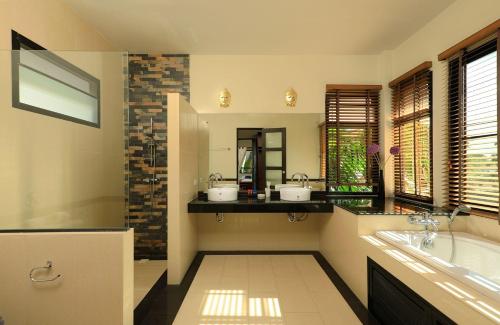 拉威海滩热带景观沙利卡别墅的浴室配有两个盥洗盆和浴缸。