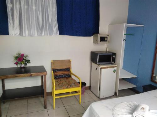 圣何塞Hotel Marruecos C.R.的小房间设有桌子、椅子和冰箱
