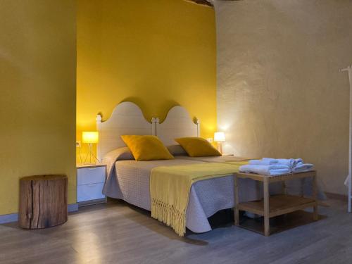 MagallónLoteta Experience的一间卧室设有一张床和黄色的墙壁