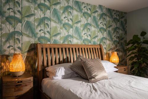 惠茨特布尔新月特纳酒店的一间卧室配有一张带两盏灯和壁纸的床。