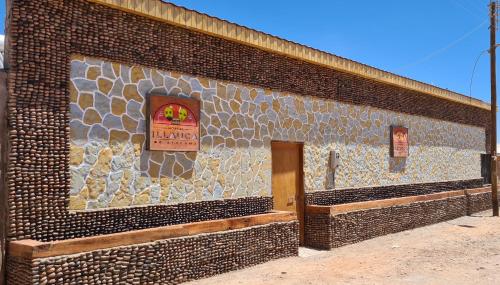 圣佩德罗·德·阿塔卡马Hostal Illauca de Atacama的砖砌的建筑,旁边标有标志